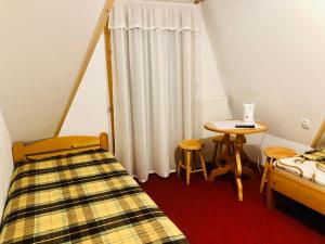 GrońにあるU Sobaliのベッド、テーブル、窓が備わる客室です。