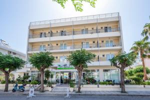 a large building with palm trees in front of it at Hotel Koala in Kos