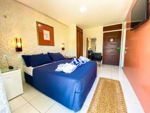 a bedroom with a blue bed in a room at Aimberê Eco Resort Hotel in Coqueiro