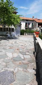 un patio de piedra con sillas y un edificio en Residenza Santa Valeria, en Caglio
