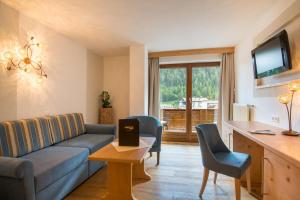 salon z kanapą, krzesłami i telewizorem w obiekcie Beauty & Wellness Hotel Tirolerhof w mieście Nauders