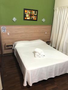 a bedroom with a bed with two towels on it at Hotel Fariña in Mar de Ajó