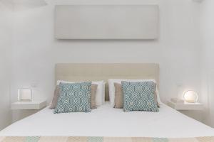 ein weißes Schlafzimmer mit einem weißen Bett mit zwei Lampen in der Unterkunft Paradise House in Noli