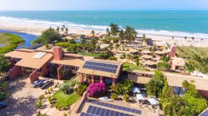 an aerial view of a house with solar panels on the beach at Aimberê Eco Resort Hotel in Coqueiro