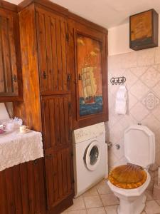 a bathroom with a toilet and a washing machine at Mili Art Home in Naxos Chora