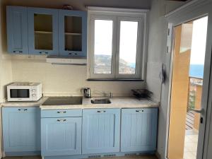 a blue kitchen with a sink and a microwave at Agriturismo "I Castellari" in Pietra Ligure
