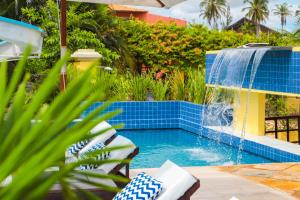 a swimming pool with a water fountain in a yard at Aimberê Eco Resort Hotel in Coqueiro