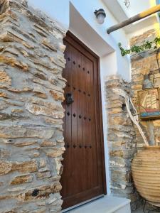 uma porta de madeira numa parede de pedra em Mili Art Home em Naxos Chora