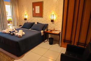 a hotel room with two beds and a table at Aimberê Eco Resort Hotel in Coqueiro