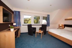 ein Hotelzimmer mit einem Bett und einem Schreibtisch in der Unterkunft Hotel Gut Vorwald in Schmallenberg