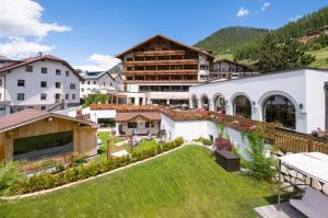 widok na ośrodek z trawnikiem i budynkami w obiekcie Beauty & Wellness Hotel Tirolerhof w mieście Nauders