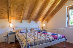 een slaapkamer met een bed en een houten plafond bij Wellness Ferienhaus Fronwald in Alpirsbach