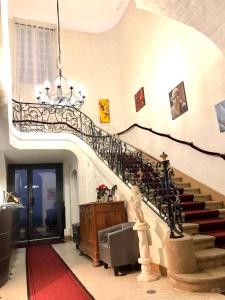 a staircase in a building with a chandelier at Hôtel Particulier CHÂTEAU DES MARAIS Proximité et vue sur le Lac de Grand lieu in Saint-Philbert-de-Grand-Lieu