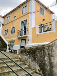 a yellow and white house with stairs in front at Sintra1012 Boutique Guesthouse in Sintra