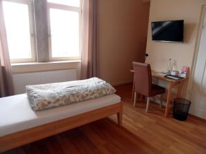 Im Bahnhof - Gästezimmer - في فايكرزهايم: غرفة نوم بها سرير وطاولة وكرسي