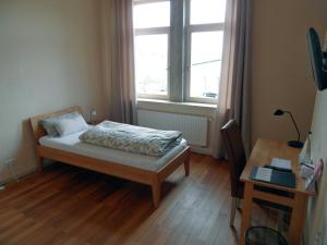 Im Bahnhof - Gästezimmer - في فايكرزهايم: غرفة نوم بسرير ونافذة ومكتب