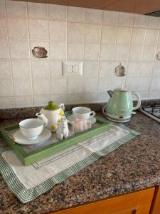 una encimera de cocina con 2 tazas de té y cuencos en una bandeja en A casa di Stella, en Salerno