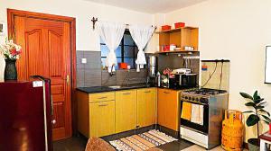 a kitchen with wooden cabinets and a stove top oven at Home and Away Cozy Studio Apartment number 407 in Nairobi