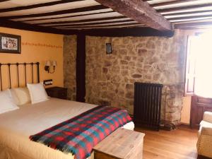 a bedroom with a bed and a stone wall at Posada la Trebede in Perrozo