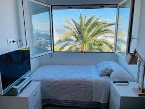 a bedroom with a bed and a palm tree at Puerto Denia Harbour Views in Denia