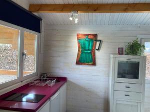 a kitchen with a sink and a painting on the wall at Hermoso Bungalow de madera in Seville
