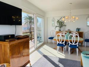 uma sala de jantar com uma televisão e uma mesa com cadeiras em Puerto Denia Harbour Views em Denia