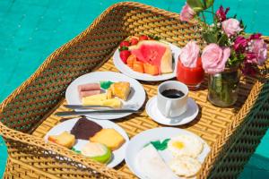 a table with plates of breakfast foods and a cup of coffee at Aimberê Eco Resort Hotel in Coqueiro