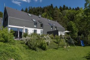 een huis met een tuin met een schommel bij Ferienhaus Dieboldsberg in Alpirsbach