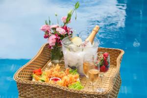 a picnic basket with food and drinks and flowers at Aimberê Eco Resort Hotel in Coqueiro