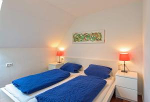 アルピルスバッハにあるFerienhaus Dieboldsbergのベッドルーム1室(青いシーツとランプ付きのベッド2台付)