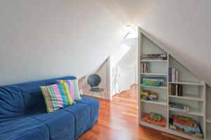 een woonkamer met een blauwe bank en een boekenplank bij Ferienhaus Dieboldsberg in Alpirsbach