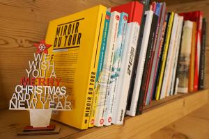 a shelf filled with books on a shelf at Hôtel Mont Thabor Serre Chevalier in La Salle-les-Alpes +32 photos