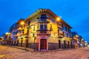 a large white building with lights on a street at Hotel Boutique Los Balcones in Cuenca
