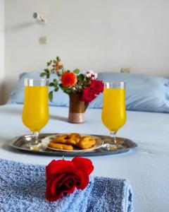 una bandeja de donuts y dos vasos de zumo de naranja en studios.maria.anna en Kamilari