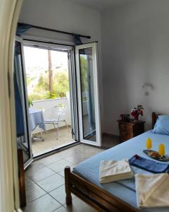 a bedroom with a bed and a sliding glass door at studios.maria.anna in Kamilari