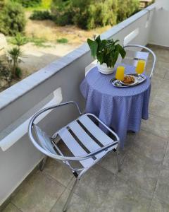 una mesa con un mantel púrpura y una silla en studios.maria.anna, en Kamilari