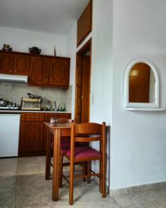 a wooden table and chair in a kitchen at studios.maria.anna in Kamilari