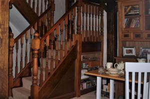 een houten trap in een kamer met een tafel bij Charming Guest House in Cornish Countryside in Bodmin
