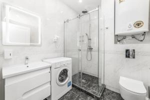 a bathroom with a washing machine and a shower at 20 Deribasivska Design Apartment in Odesa +6 photos