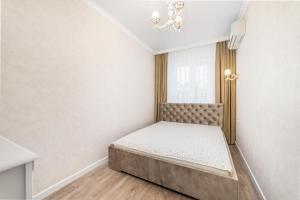 a small bedroom with a bed and a window at 20 Deribasivska Design Apartment in Odesa