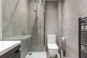 uma casa de banho com um chuveiro, um WC e um lavatório. em Stunning 3 Bedroom Flat in Bruntsfield em Edimburgo