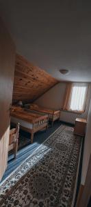 a attic room with two beds and a rug at Bed and Breakfast Vila Lala in Jahorina