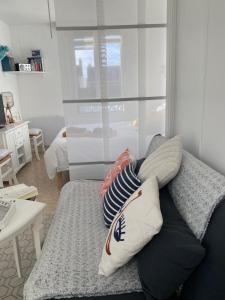 uma sala de estar com um sofá com almofadas em Studio cocooning em Saint Malo