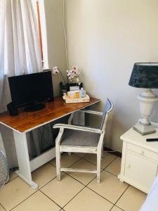 una scrivania con monitor e sedia di Cozy guest suite with private access a Roodepoort