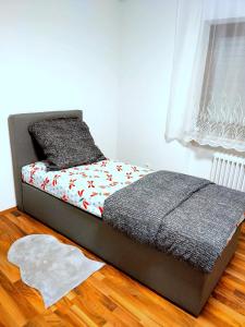 a small bed in a bedroom with a wooden floor at Ferienwohnung Michelbach an der Bilz mit Parkplatz und Küche für 1 bis 5 Personen in Michelbach an der Bilz