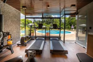 an indoor gym with a swimming pool and glass walls at Hotel Ritta Höppner in Gramado