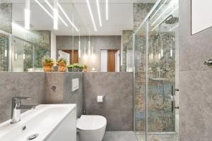 a bathroom with a toilet and a sink and a shower at Central Apartments by Bed&Bath in Kraków +235 photos