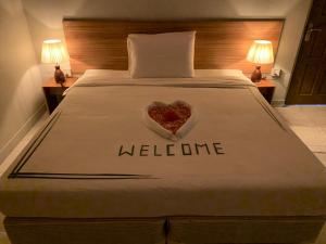 a bed with a heart on it with the word welcome at Royal Beach Dhigurah in Dhigurah