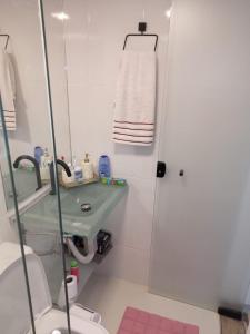 a bathroom with a sink and a toilet and a mirror at Estúdio no Condomínio Acquaville in Ilhabela
