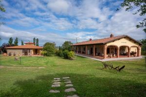 a house in a field with a grass yard at Agriturismo La Banchella in Scarlino